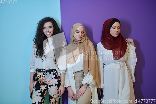 Image of Young muslim women posing on purple and blue background