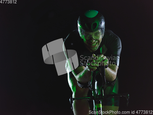 Image of triathlon athlete riding bike at night