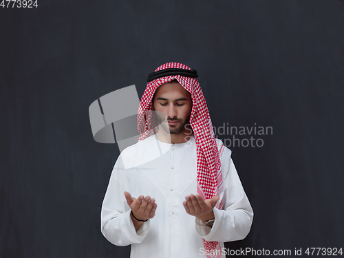 Image of Arab man in traditional clothes praying to God or making dua