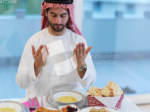 Image of Muslim man making iftar dua to break fasting during Ramadan