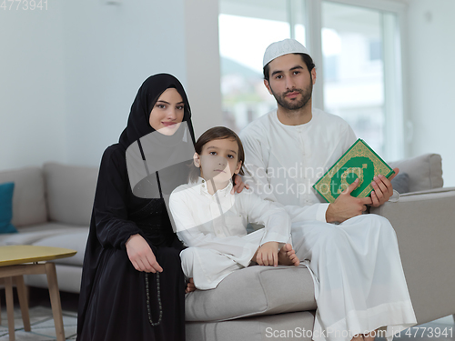 Image of Young muslim family reading Quran during Ramadan