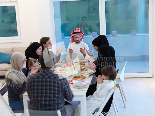 Image of Muslim family making iftar dua to break fasting during Ramadan