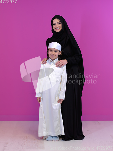 Image of young arabian mother and son wearing traditional clothes