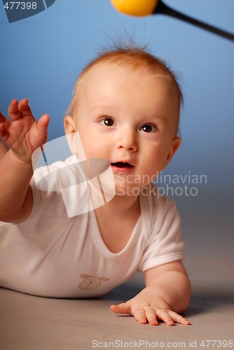 Image of Little boy trying to touch a toy