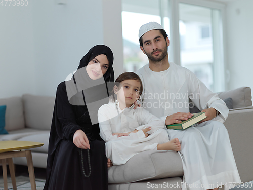 Image of Young muslim family reading Quran during Ramadan