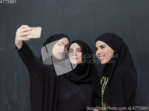 Image of Portrait of Arab women wearing traditional clothes or abaya taking selfie