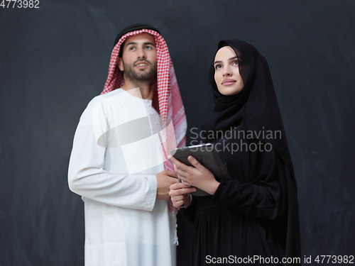 Image of Young muslim business couple using technology devices