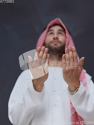 Image of Arab man in traditional clothes praying to God or making dua