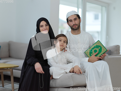 Image of Young muslim family reading Quran during Ramadan