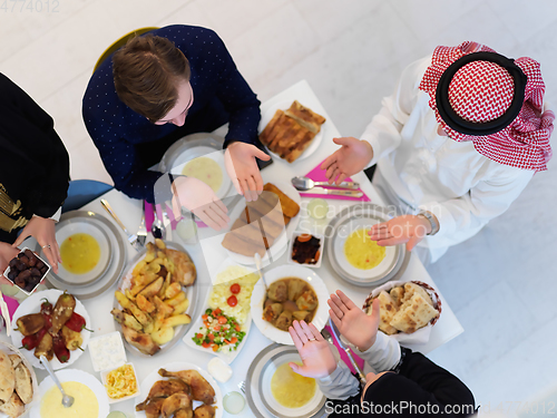 Image of Top view of Muslim family making iftar dua to break fasting during Ramadan