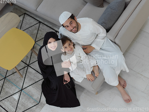 Image of Top view of young arabian muslim family wearing traditional clothes