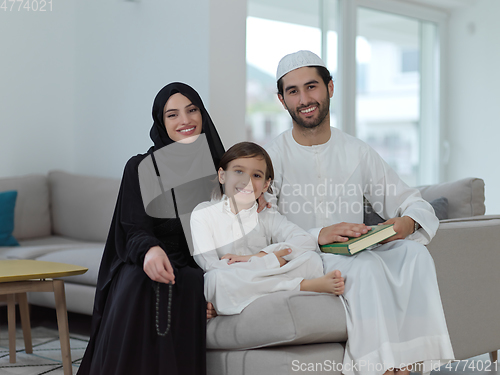 Image of Young muslim family reading Quran during Ramadan