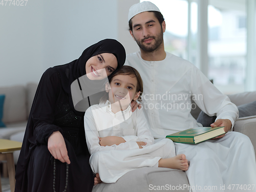 Image of Young muslim family reading Quran during Ramadan