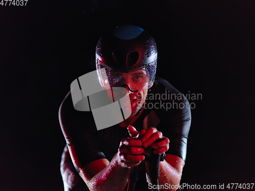 Image of triathlon athlete riding bike at night