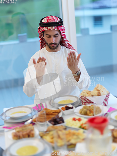 Image of Muslim man making iftar dua to break fasting during Ramadan