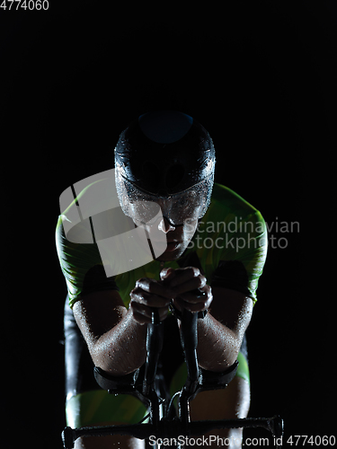 Image of triathlon athlete riding bike on rainy night