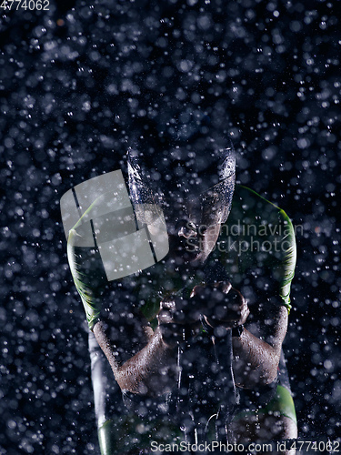 Image of triathlon athlete riding bike on rainy night