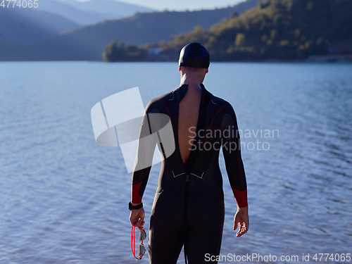 Image of triathlete swimmer portrait wearing wetsuit on training