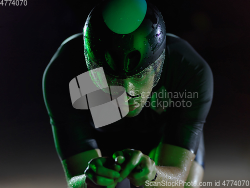 Image of triathlon athlete riding bike at night