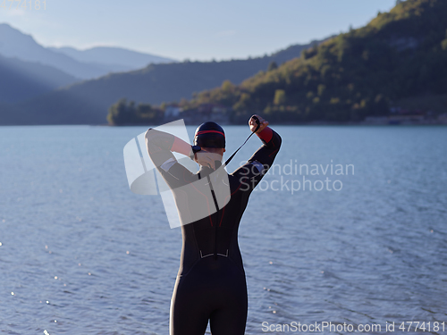 Image of triathlete swimmer portrait wearing wetsuit on training