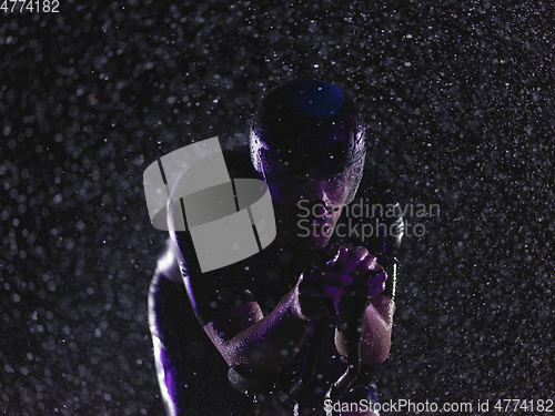 Image of triathlon athlete riding bike on rainy night