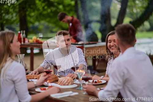 Image of friends having picnic french dinner party outdoor during summer holiday