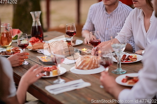 Image of friends having picnic french dinner party outdoor during summer holiday