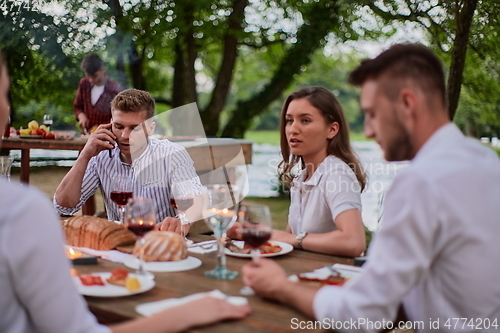 Image of friends having picnic french dinner party outdoor during summer holiday