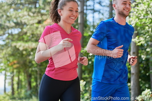 Image of couple enjoying in a healthy lifestyle while jogging on a country road