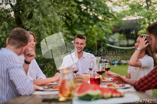 Image of friends having picnic french dinner party outdoor during summer holiday