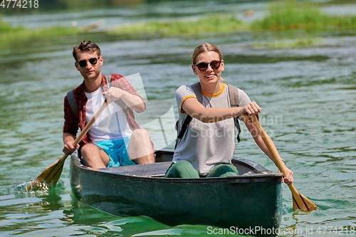 Image of friends are canoeing in a wild river