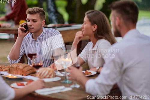 Image of friends having picnic french dinner party outdoor during summer holiday