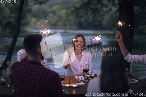 Image of friends having picnic french dinner party outdoor during summer holiday