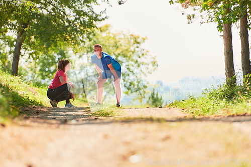 Image of couple enjoying in a healthy lifestyle while jogging on a country road