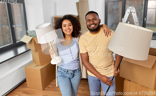 Image of happy couple packing boxes and moving to new home