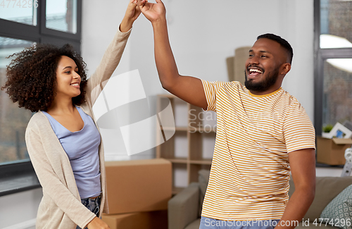 Image of happy couple moving to new home and dancing