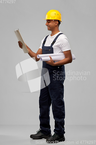 Image of happy indian builder with blueprint and clipboard