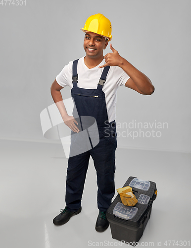 Image of happy worker or builder making phone call gesture