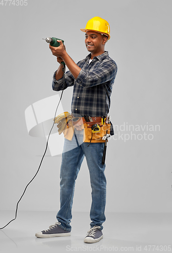 Image of happy indian builder in helmet with electric drill