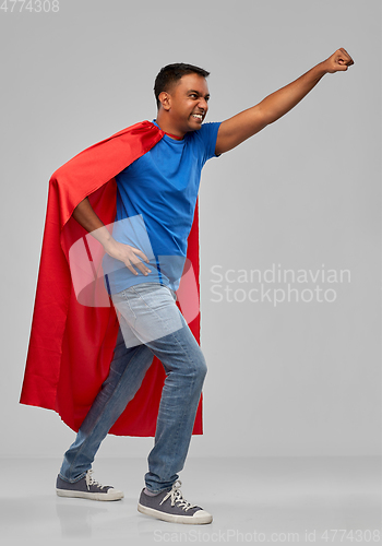 Image of indian man in superhero cape makes winning gesture