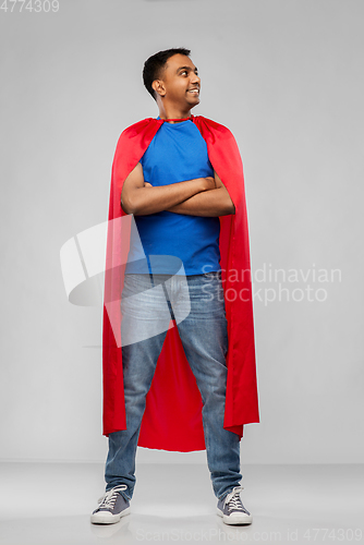 Image of happy smiling indian man in red superhero cape