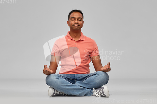 Image of happy indian mant meditating in lotus yoga pose