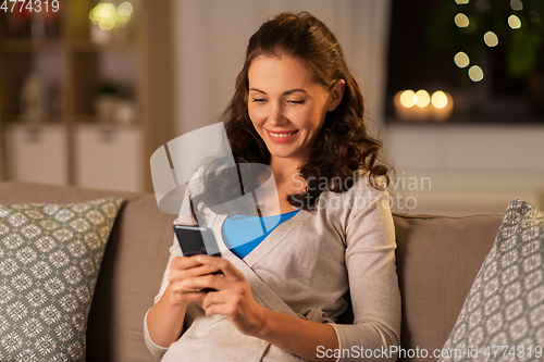 Image of woman with smartphone at home