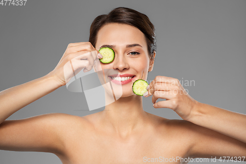 Image of beautiful woman making eye mask of cucumbers