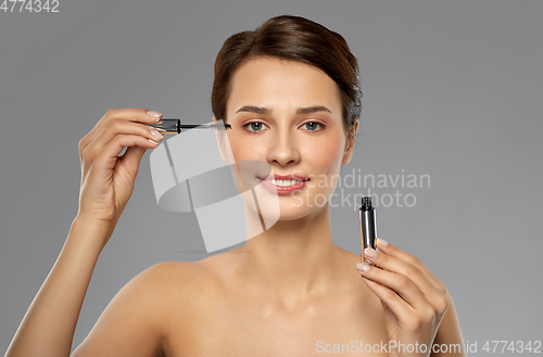 Image of beautiful woman applying mascara