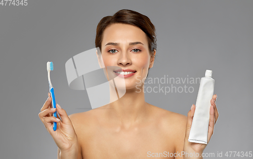 Image of smiling woman with toothbrush cleaning teeth