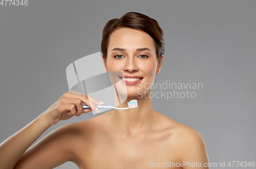 Image of smiling woman with toothbrush cleaning teeth