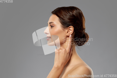 Image of beautiful young woman pointing finger to her ear