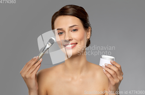 Image of beautiful young woman with facial mask and brush