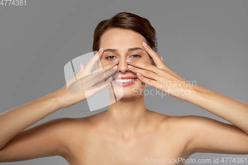 Image of beautiful young woman touching her face